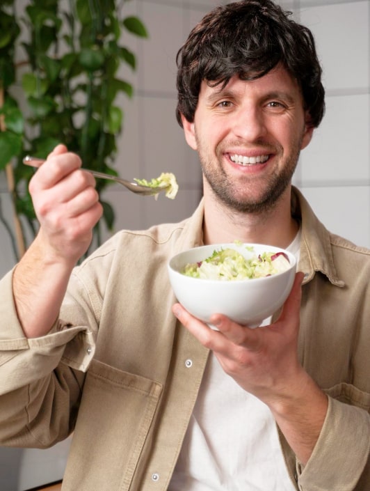 Мужчина, завтракающий салатом